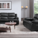 A black leather recliner sofa and a 3-seater sofa arranged in a living room setting with a modern design.